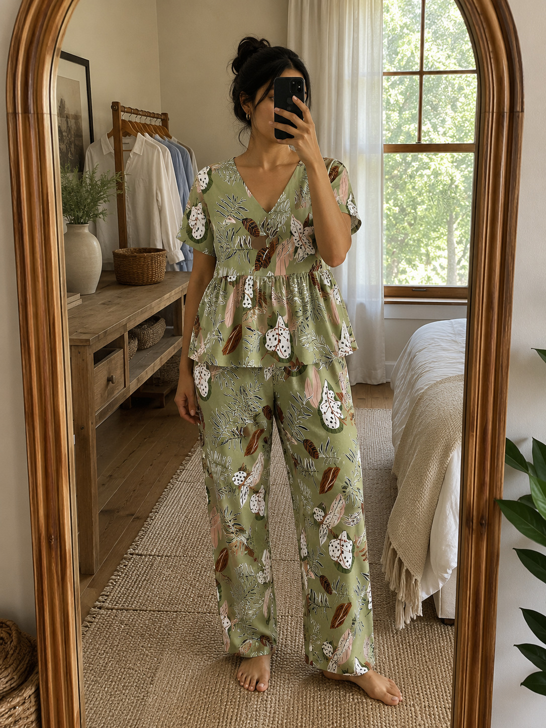 Woman wearing a premium sage green botanical print cotton peplum night suit with a V-neck top and matching straight-fit lounge pants by Irah Vastra.