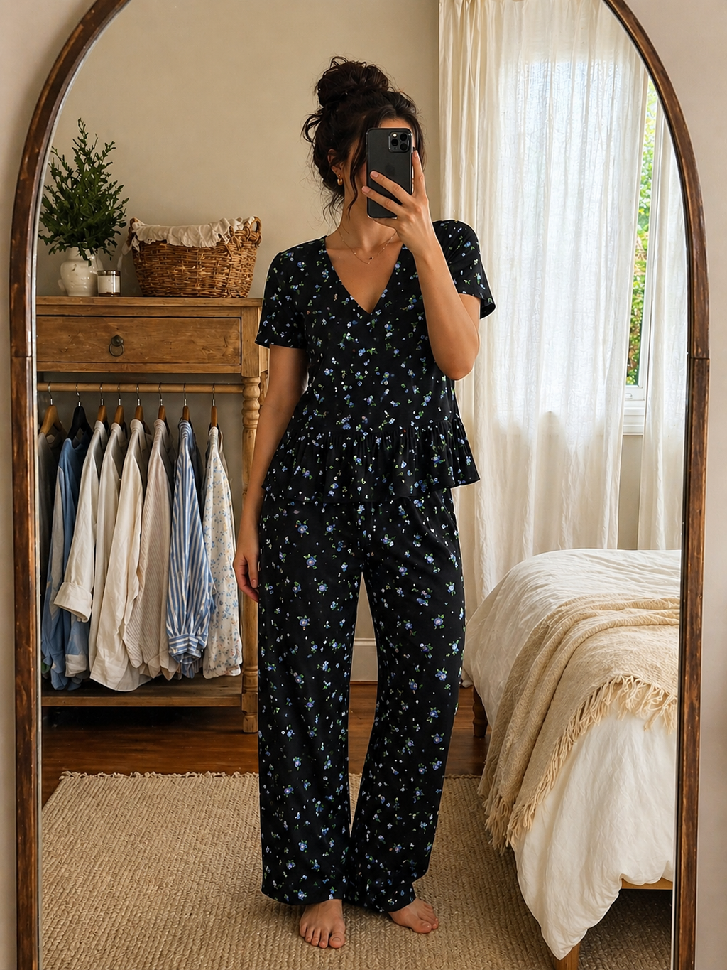 Woman wearing black floral cotton nightwear set with peplum top and full-length pajama pants in bedroom mirror selfie